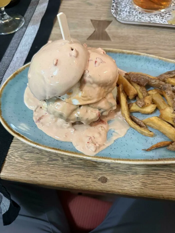Burger smothered in pink sauce served with fries as one of many questionable food combos.
