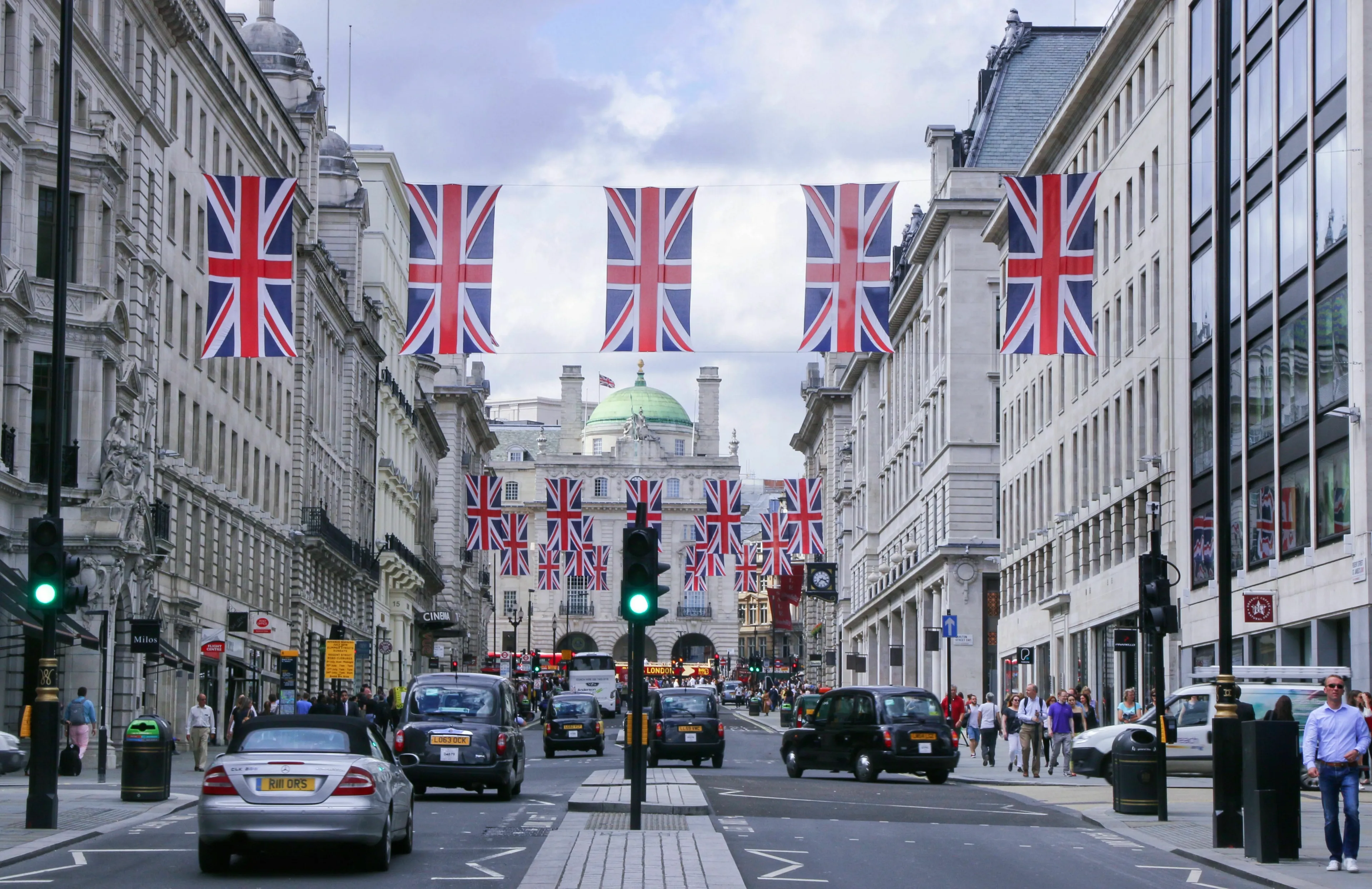 Regent Street in London, adorned with Union Jack flags, exemplifying British spelling variations in English.