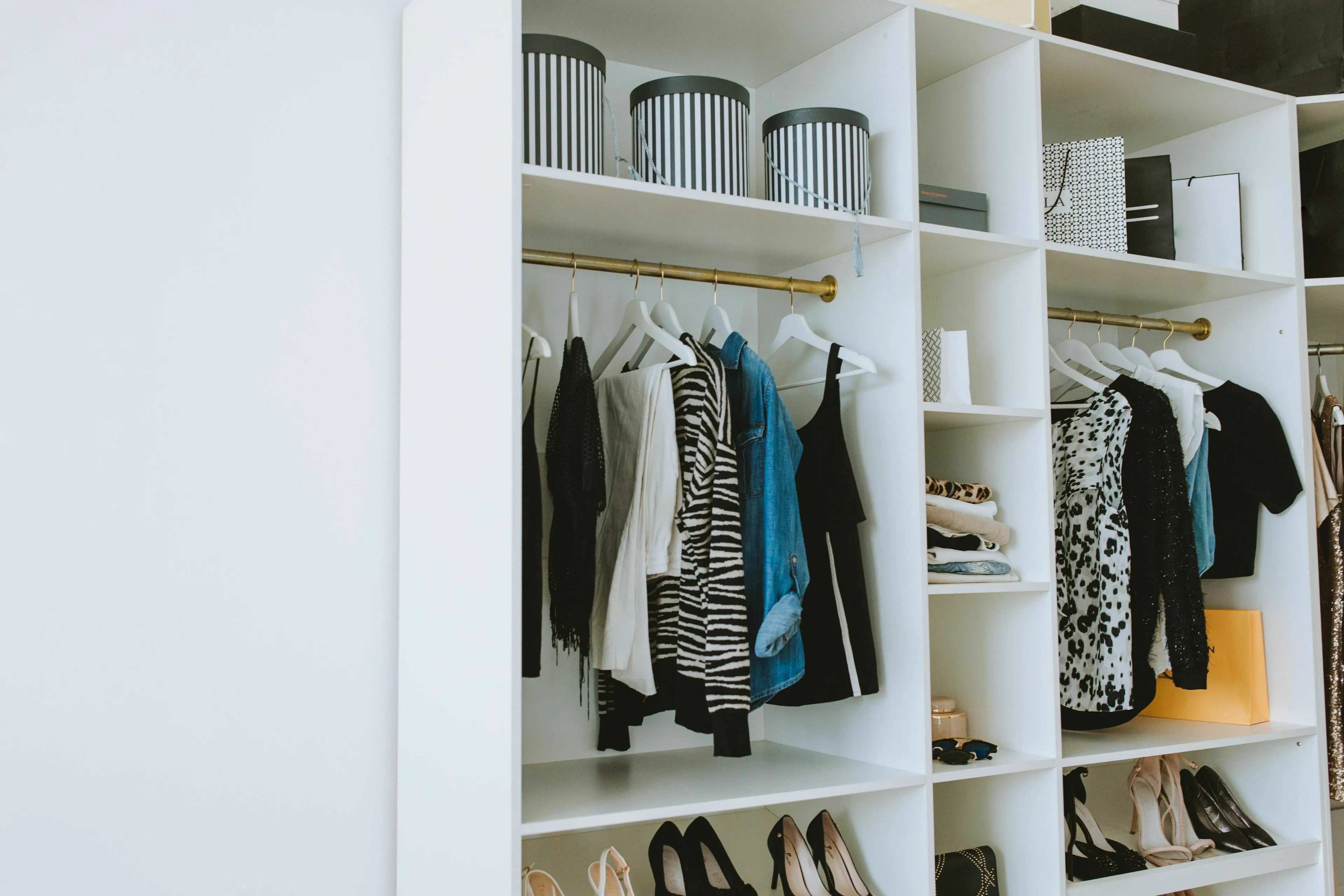 A closet with shelves and hanging clothes, illustrating American vs British English words for storing solutions.