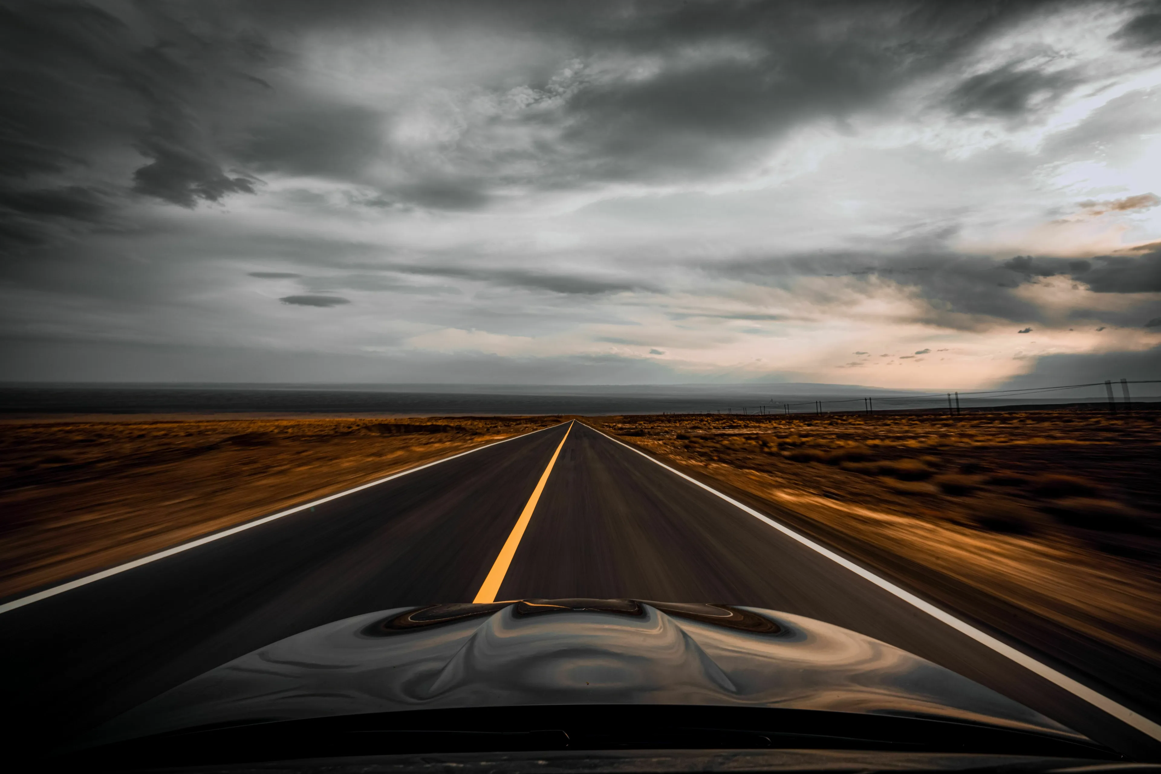 An open road stretches into the horizon, representing a one-way trip with no return date in a new world.