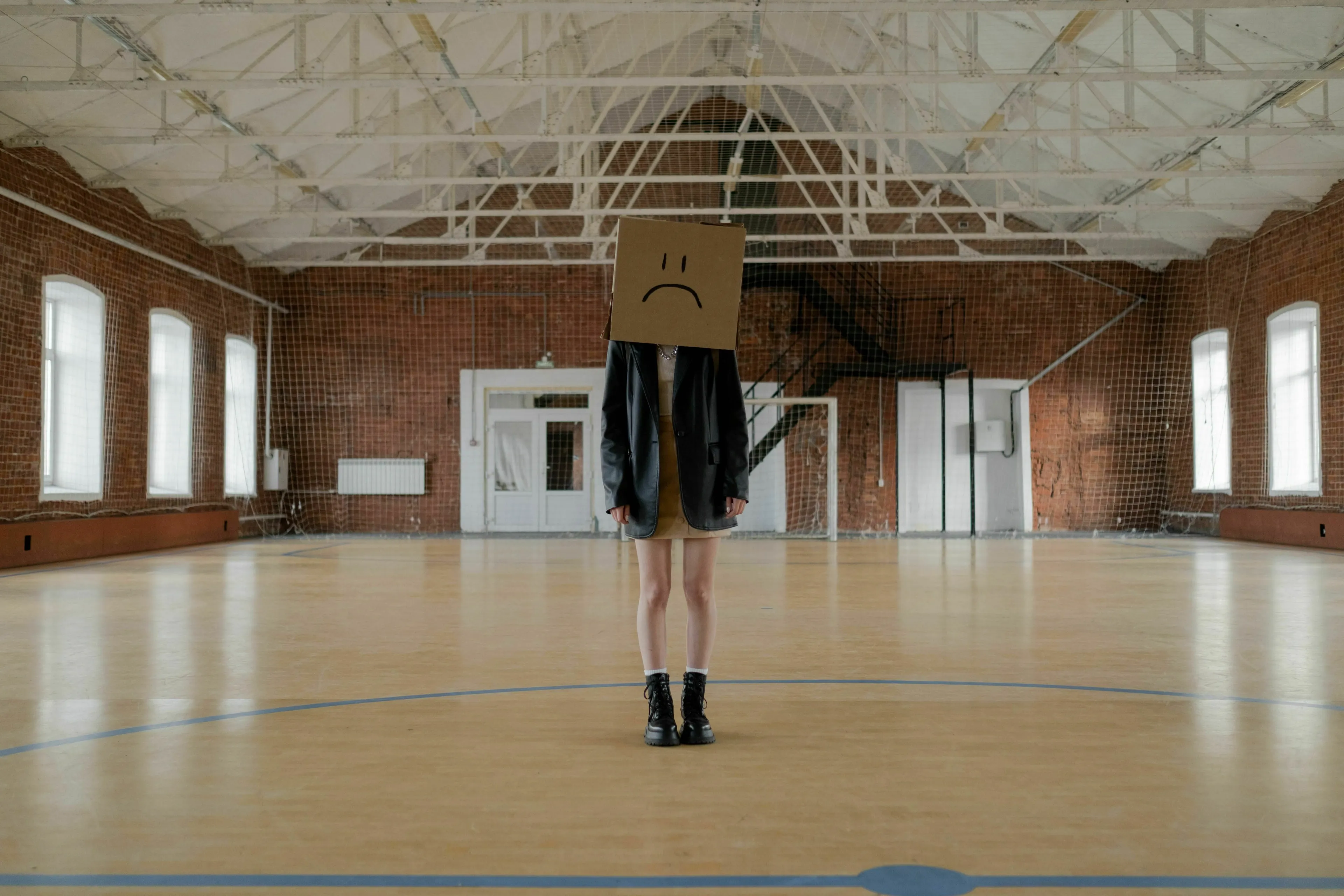 A person with a sad face cardboard box on their head, expressing a pet peeve in a utopia or dystopia.