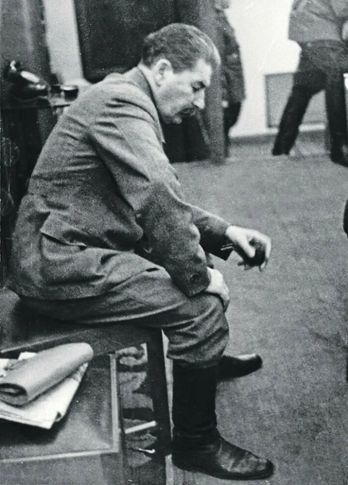 Beautiful photo from history of Joseph Stalin sitting, head down, holding a small item in his hand