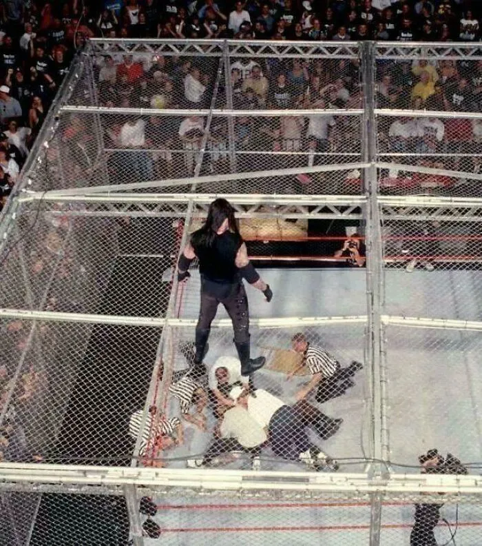 The Undertaker Looks Down At Medical Staff Checking On Mankind After He Fell, Unscripted, Through The Top Of H**l In A Cell Into The Ring 16ft Below. June 28, 1998