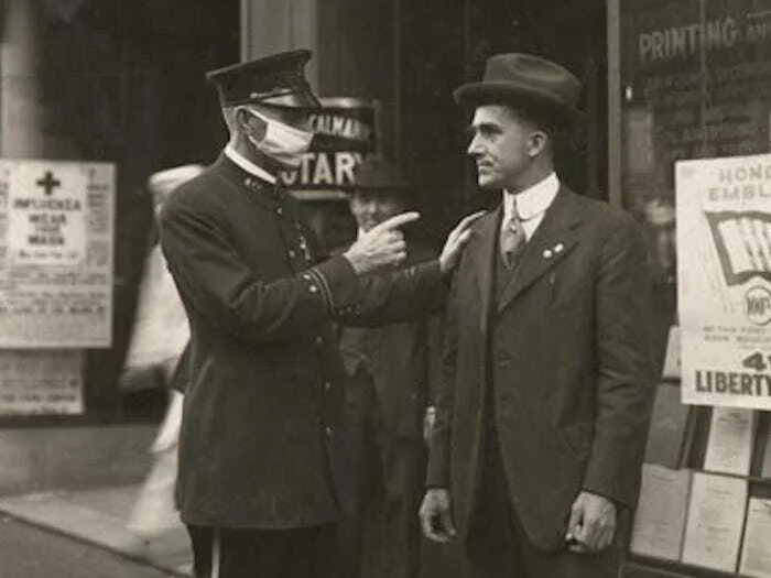 Heartbreaking historical photo of a police officer confronting a man without a mask during the influenza, interesting.