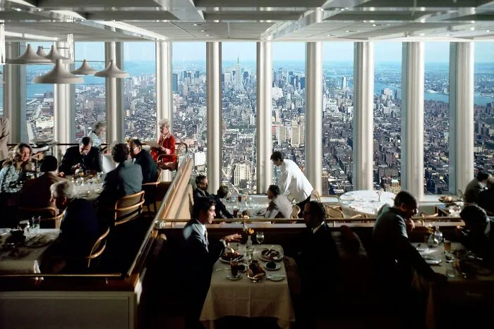 A restaurant with a panoramic view of the New York City skyline, a beautiful photo from history.