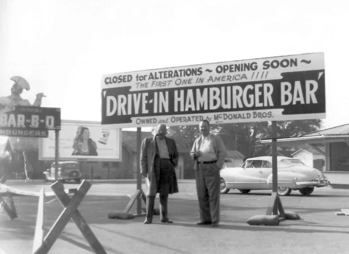 Two men standing in front of the first McDonald's Drive-In Hamburger Bar, an interesting photo from history.
