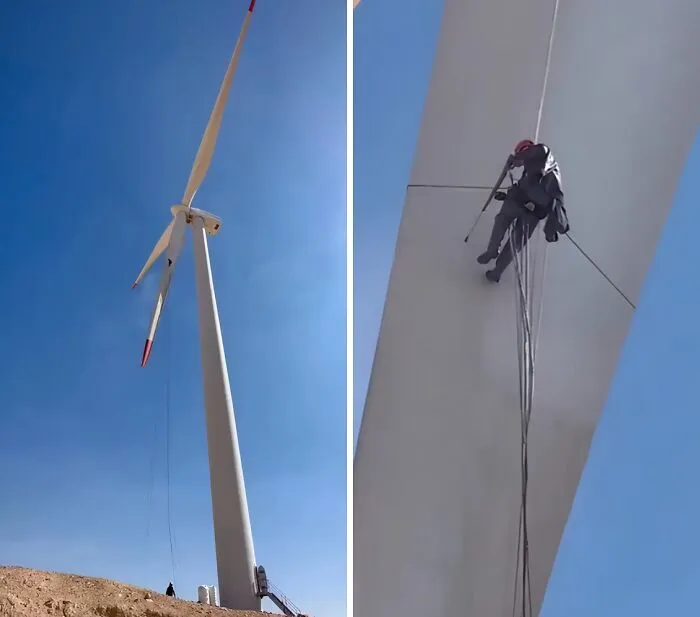 A worker rappelling down a wind turbine for maintenance, showing the process of power washing for satisfying cleaning.