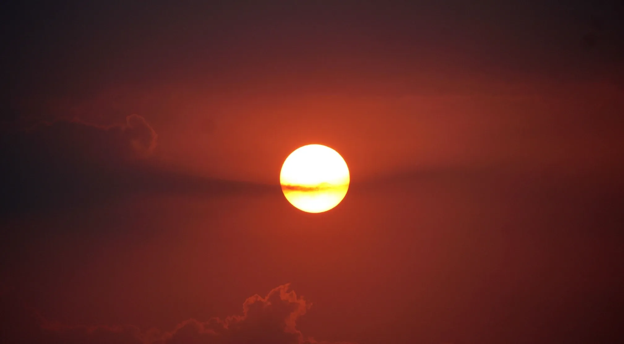 A bright sun sets in an orange sky with dark clouds. Elementary school true or false: The sun is a planet?