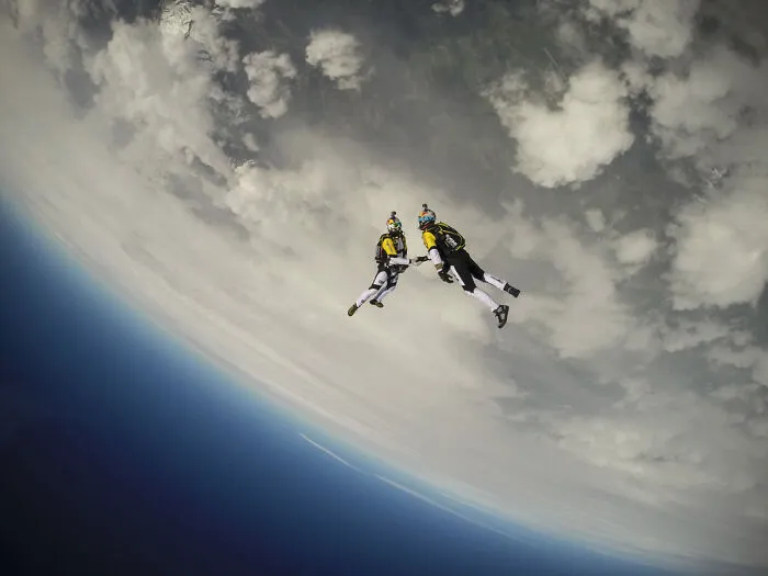 Two skydivers freefalling high above Earth, capturing fascinating finds and showing a unique perspective.