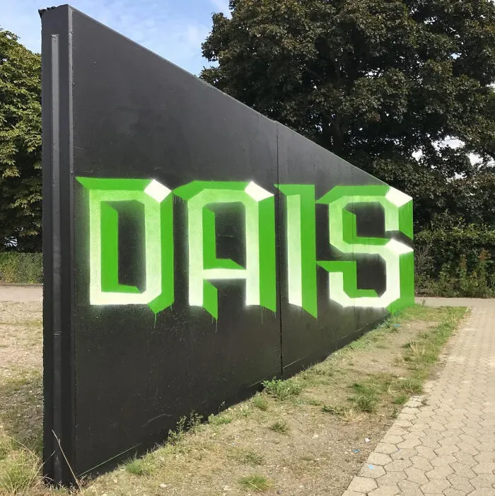 DAIS graffiti in green and white on a black wall, one of many fascinating finds.