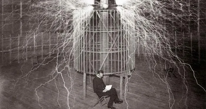 Nikola Tesla sitting calmly in his Colorado Springs lab amidst huge electrical discharges, a fascinating find.