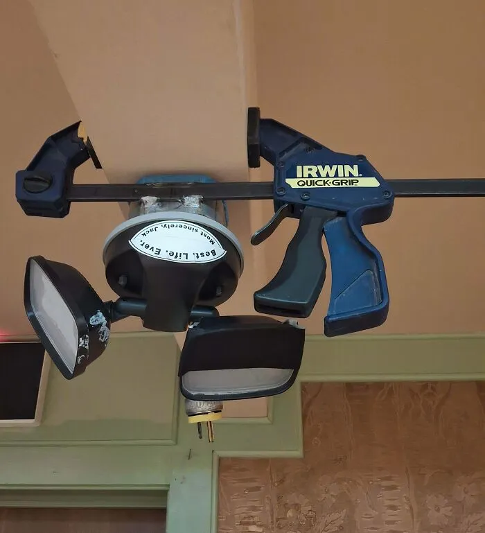An Irwin quick-grip clamp holding a light fixture, a clever solution for random junk.