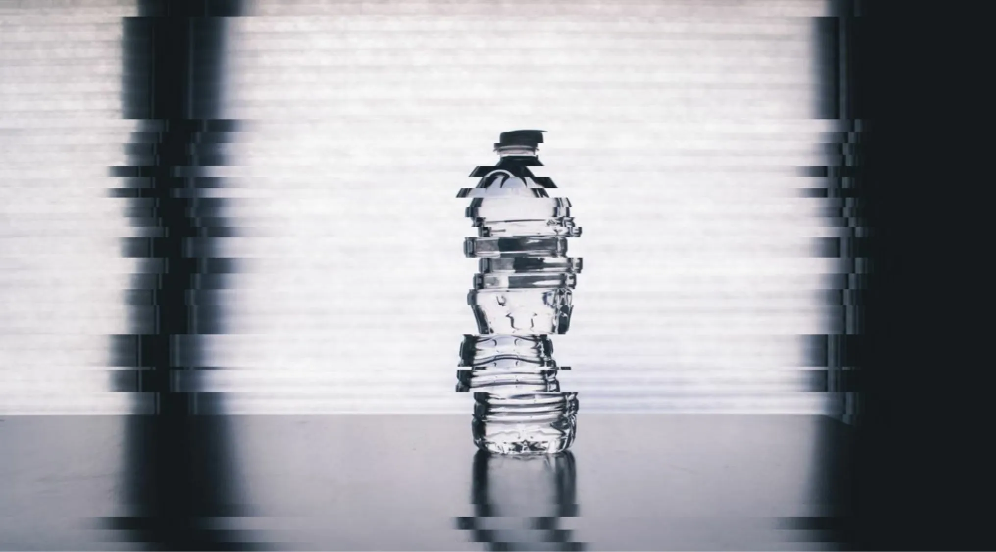 A glitched and distorted image of a water bottle, what object is hiding?