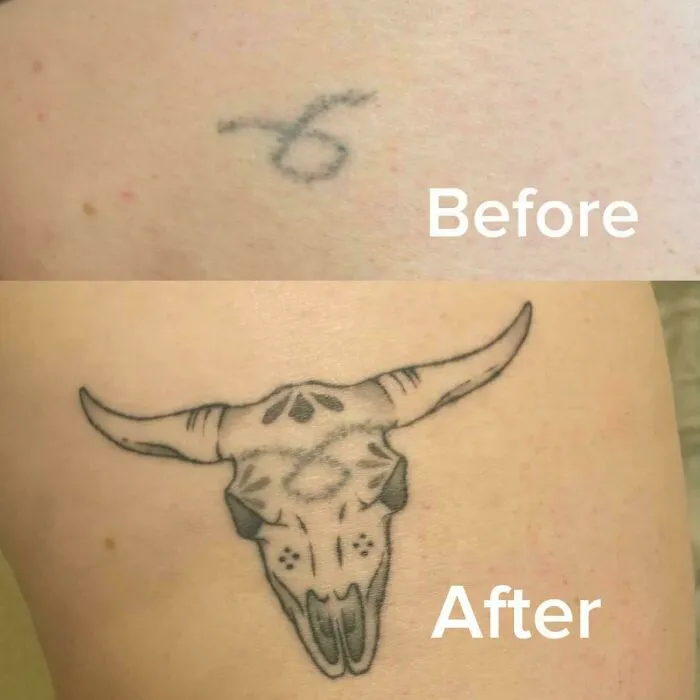A small, faded old tattoo of a number 6 transformed into a detailed bull skull cover-up design.