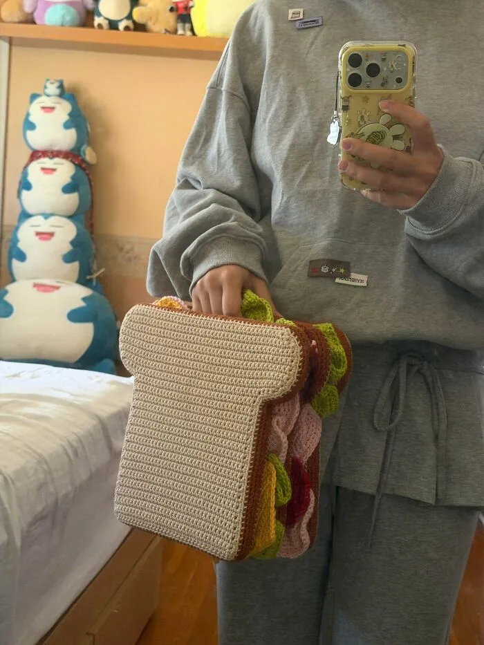 Handmade crochet sandwich shaped handbag held by person