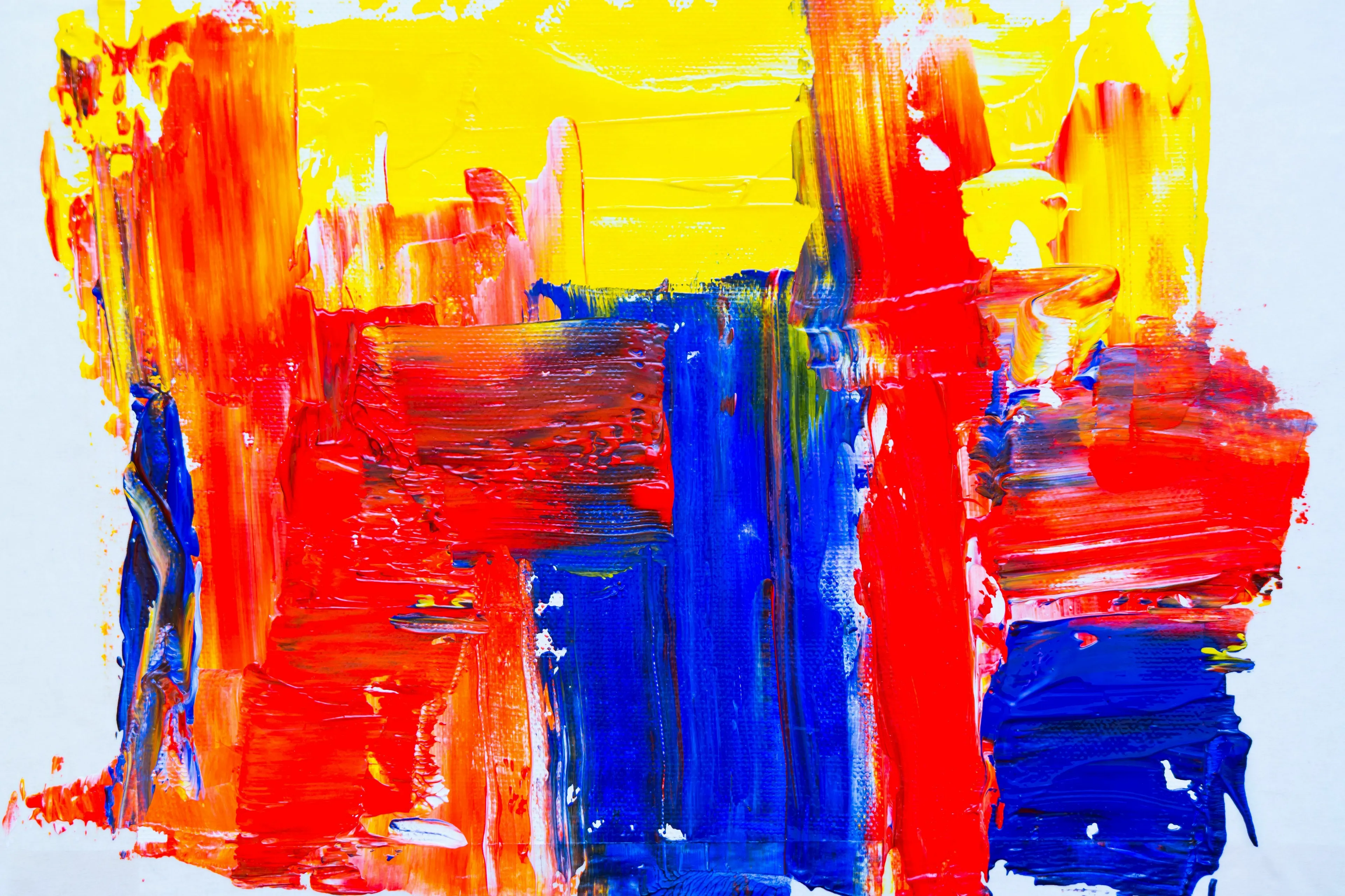 A vibrant abstract painting with bold strokes of blue and yellow, exploring the art of color mixing.