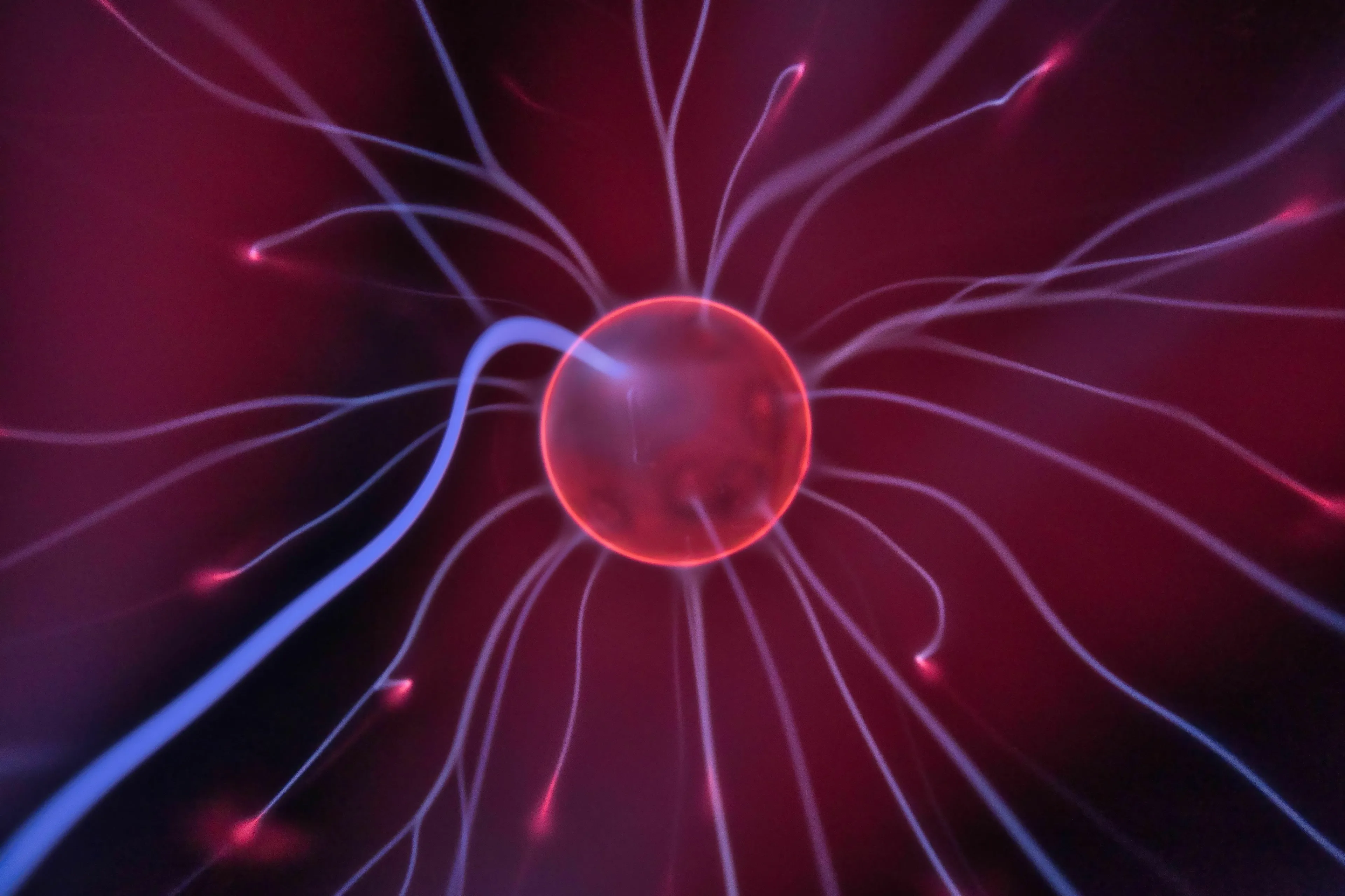 A plasma ball with electrical discharges, symbolizing a negatively charged particle in science.