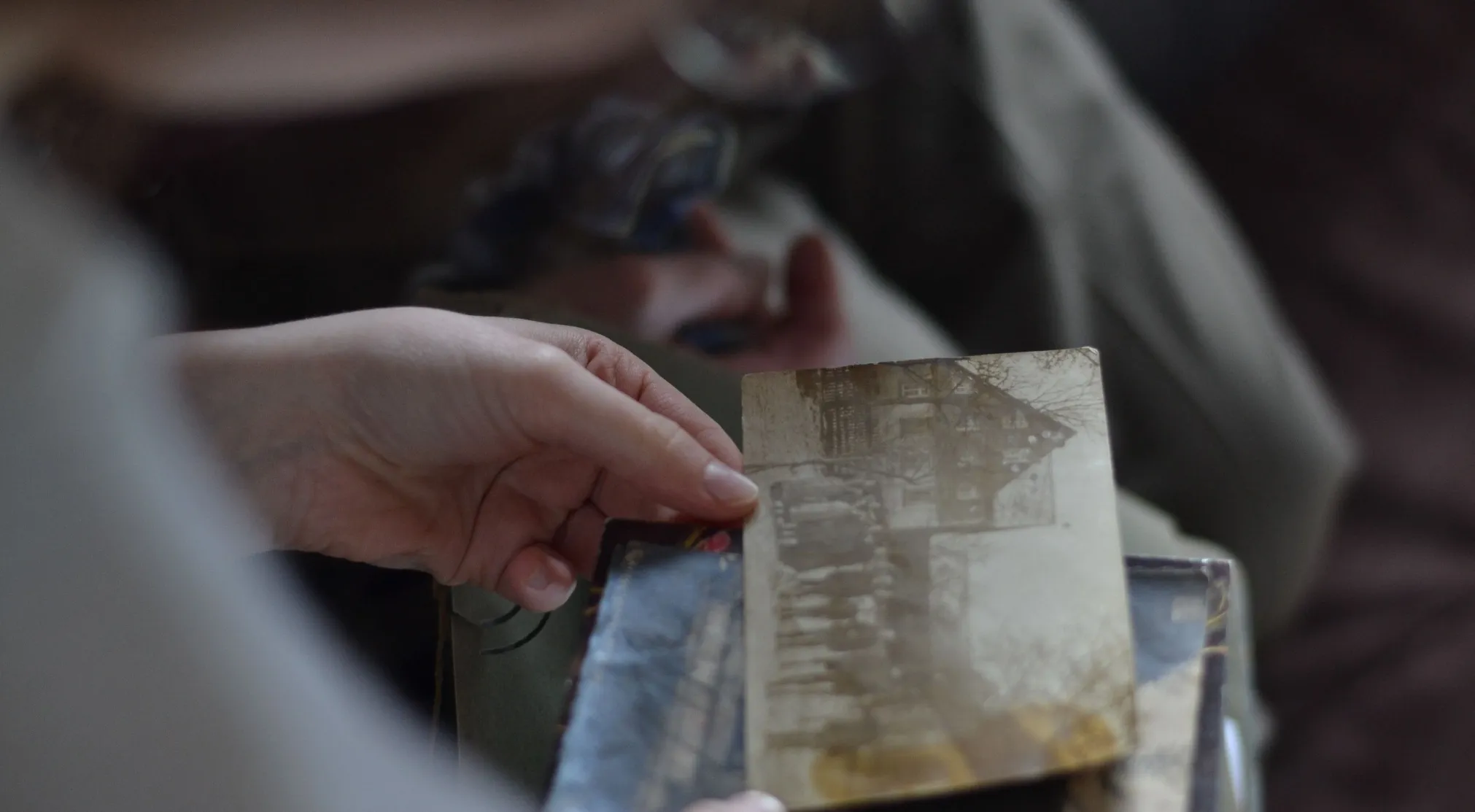 A person's hands delicately hold an old, faded photograph, possibly hinting at how memories are passed down through generations. FBI quiz.