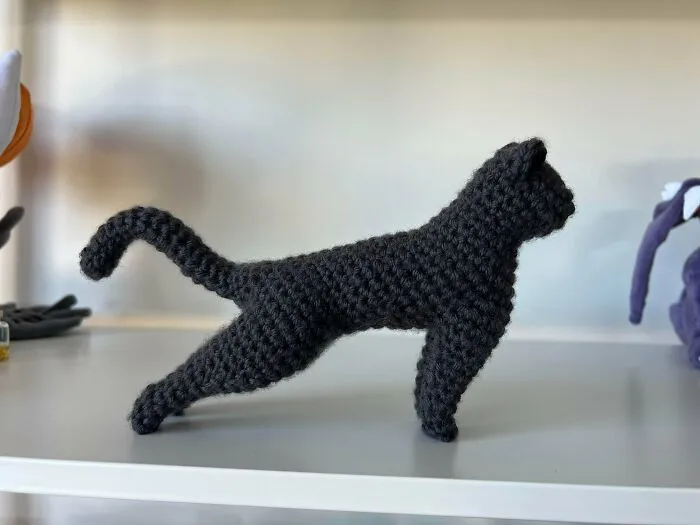 Crochet black cat figurine standing on a shelf