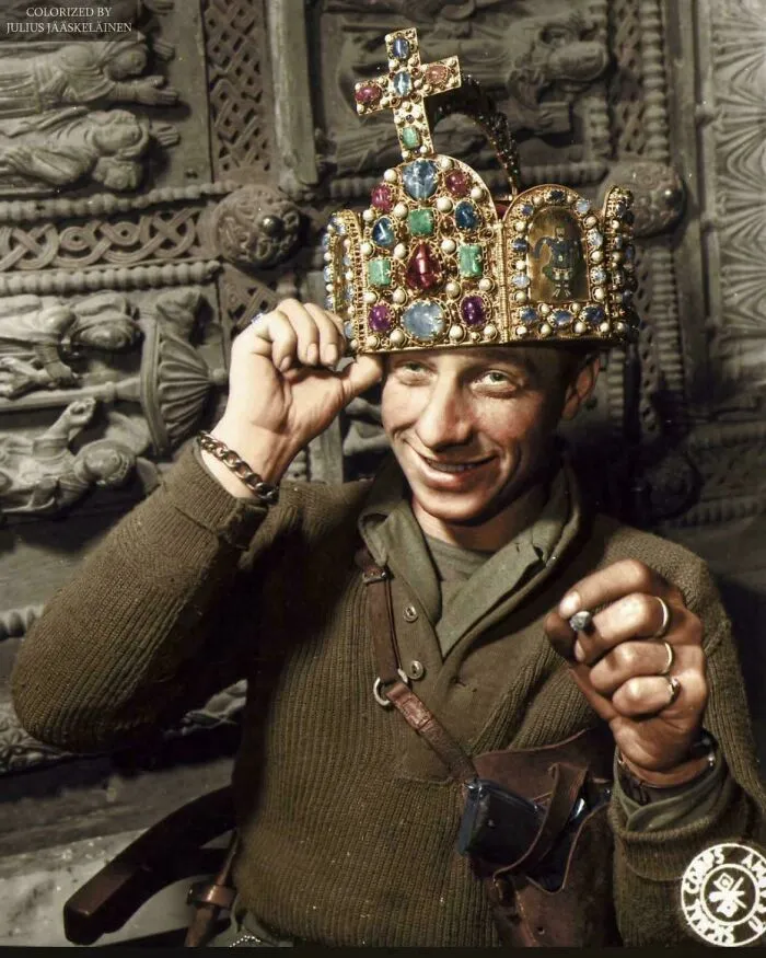A smiling American soldier trying on a jeweled crown, a rare photo from American history.