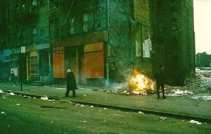 A fascinating photo from American history shows a desolate street scene with a fire burning, discarded trash, and two figures.