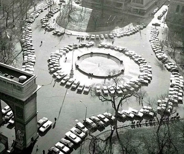 An aerial view of cars parked in a circle around a fountain, a fascinating photo from American history.