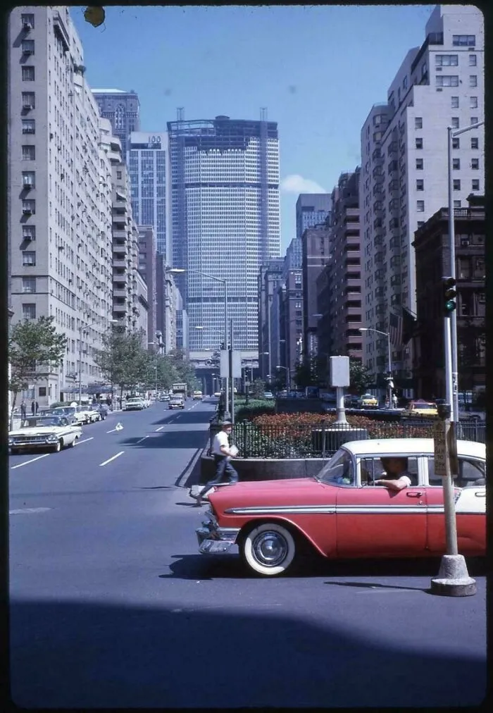 A vibrant street scene with a pink and white vintage car, capturing a fascinating moment in American history.