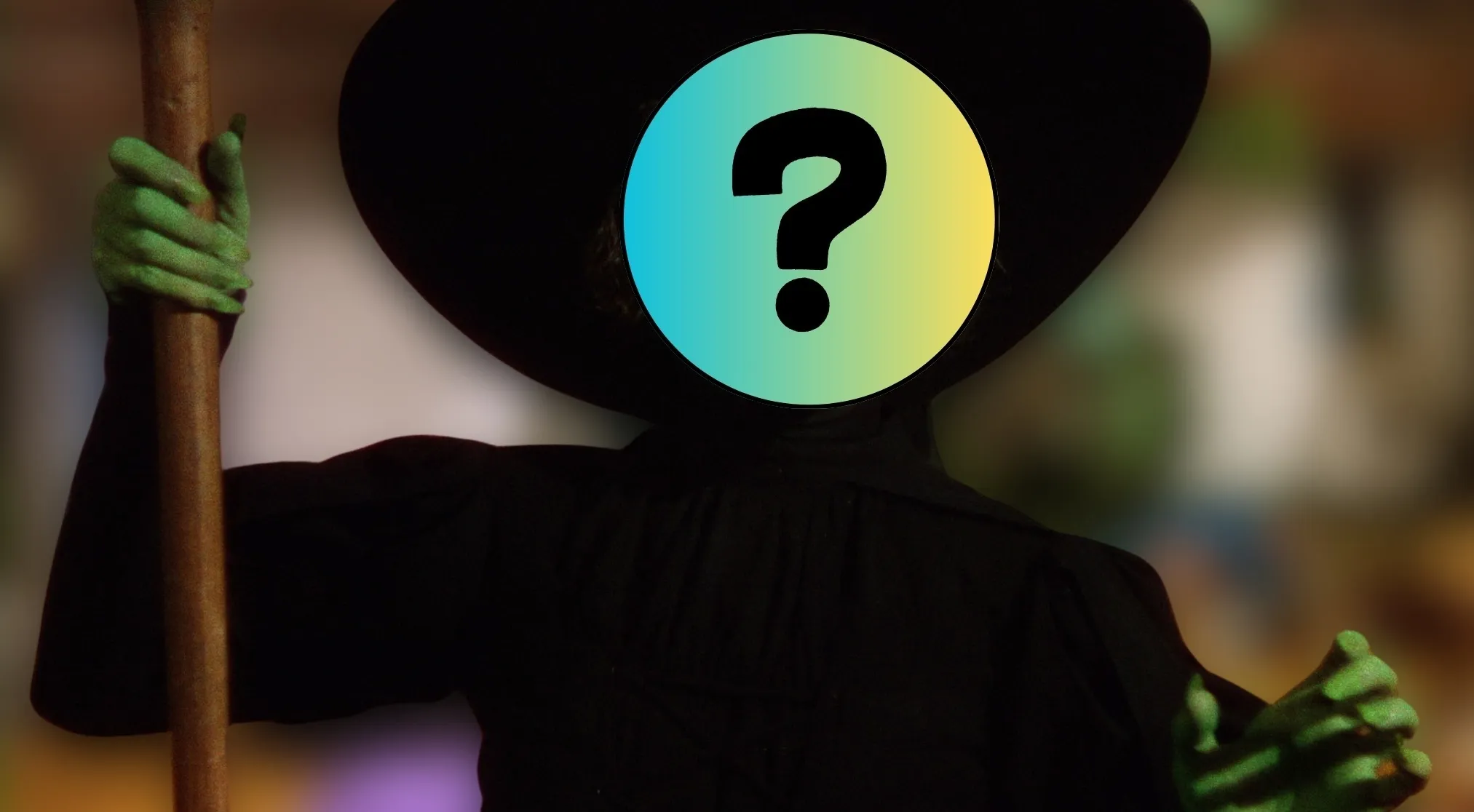 A silhouette of a villain in a black outfit and pointed hat with green hands gripping a staff. Guess the villain by their outfit.
