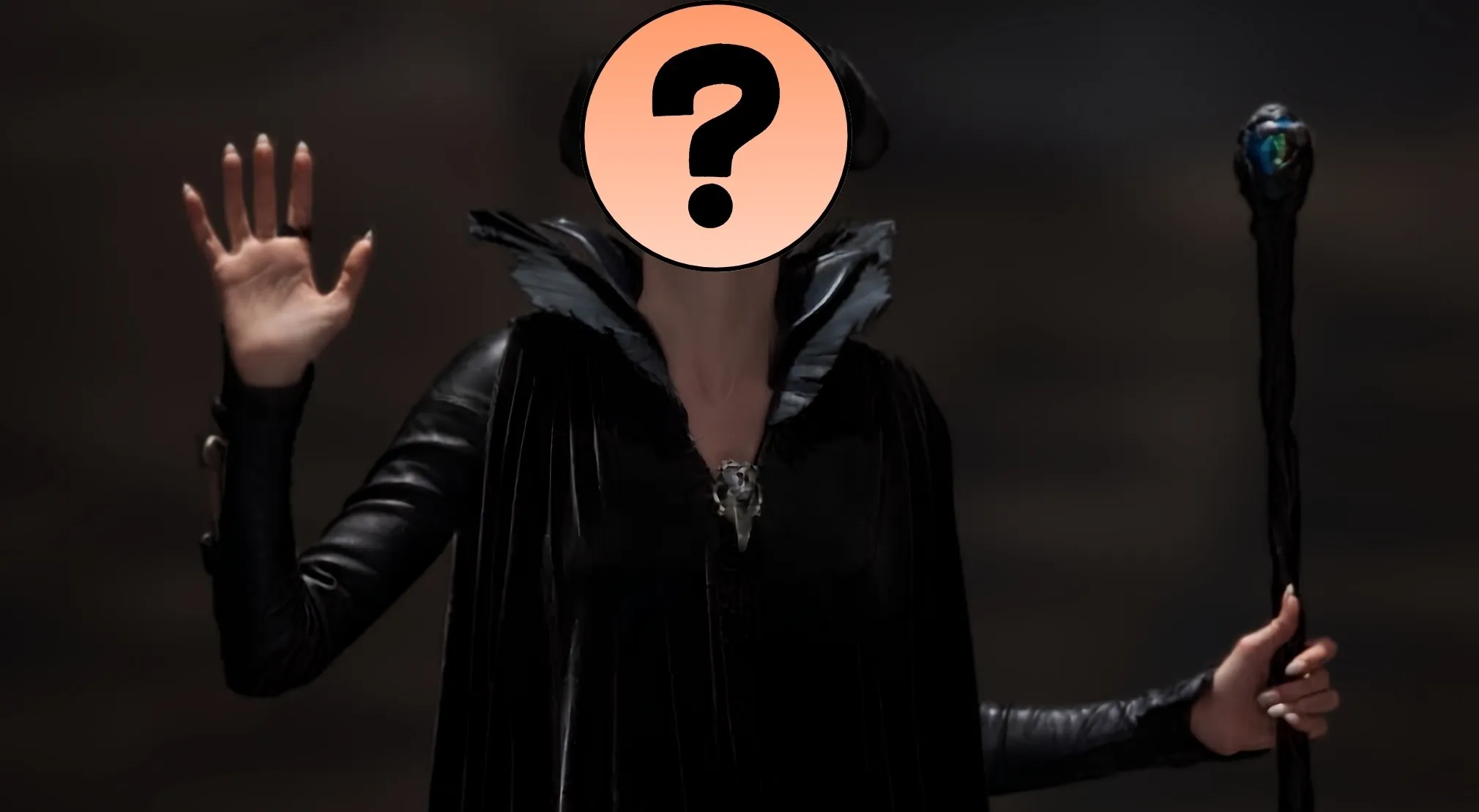 An unknown villain in a black cloak with a large collar, holding a staff. Guess the villain by their outfit.