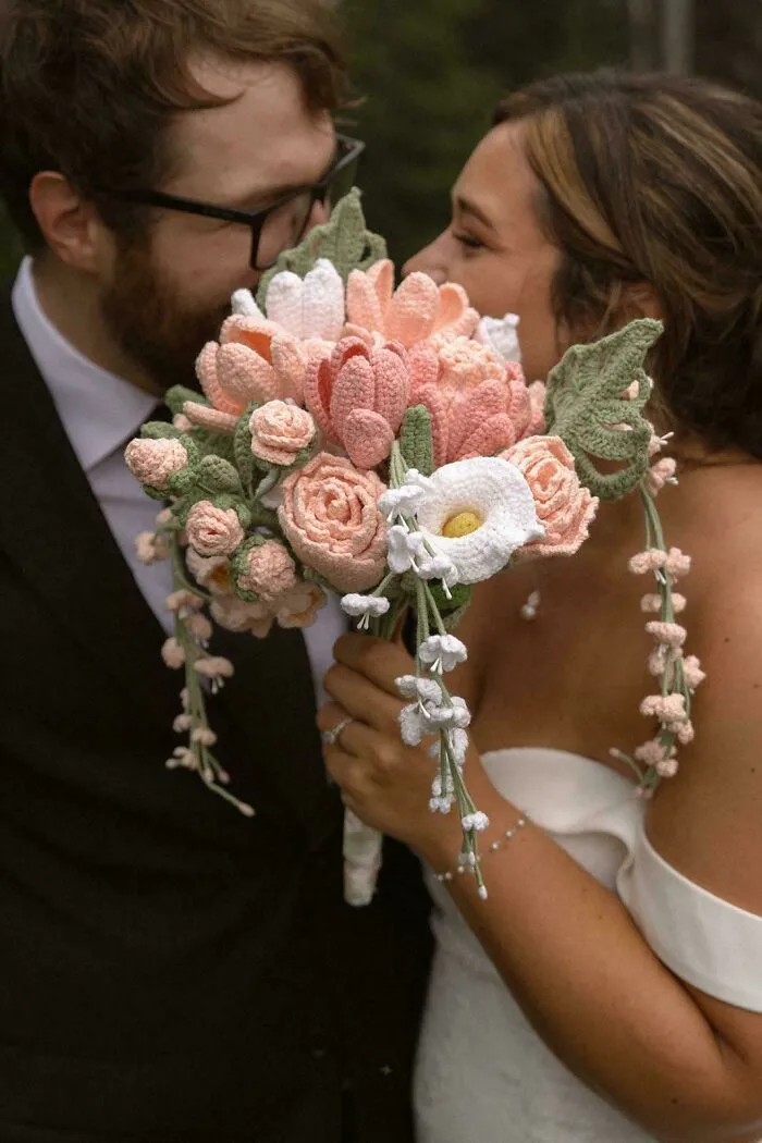 Bride holding a crochet flower bouquet with peach and white flowers