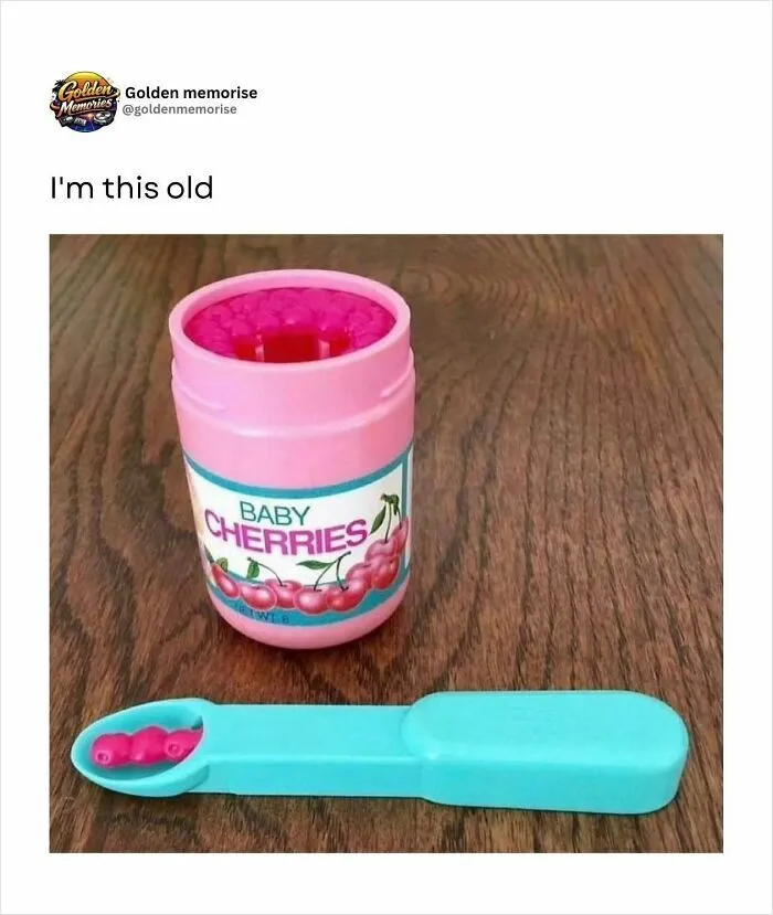 A pink container of Baby Cherries lip gloss with a turquoise applicator, evoking 90s nostalgia and golden memories.