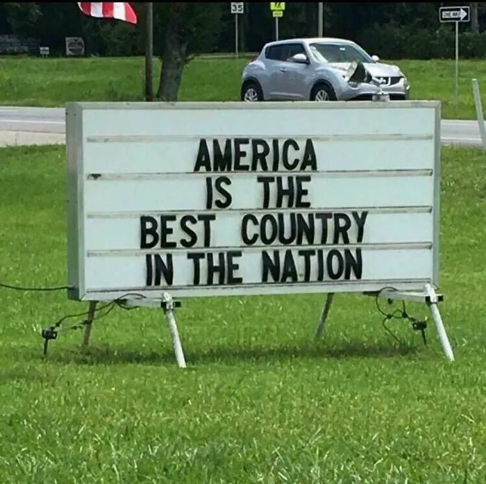 A sign on a lawn that reads AMERICA IS THE BEST COUNTRY IN THE NATION, an example of how dumb people are.