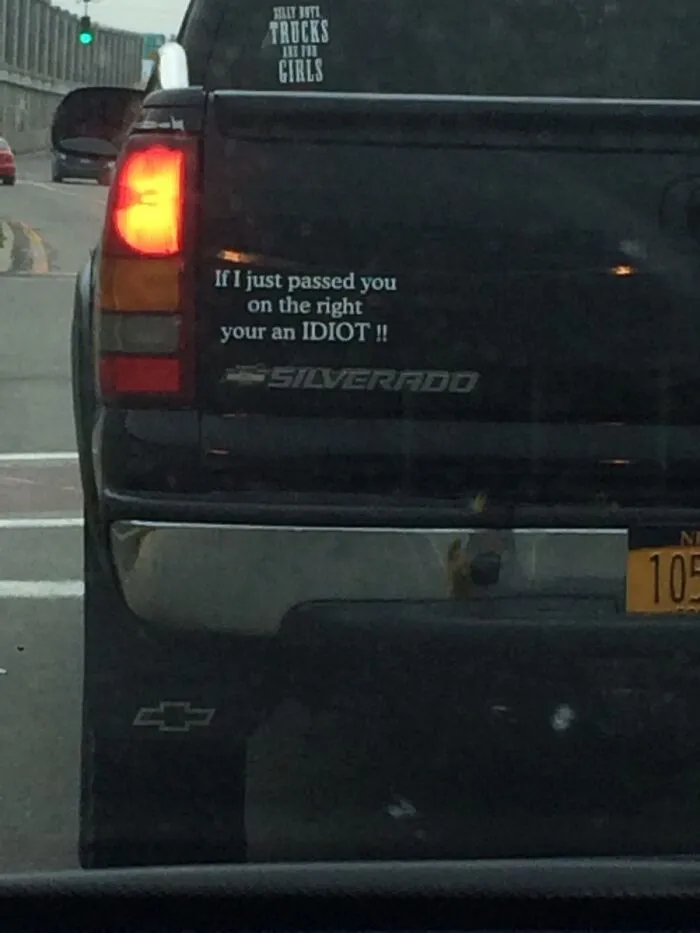 Rear view of a pickup truck with a bumper sticker that reads If I just passed you on the right your an IDIOT, highlighting dumb moments.