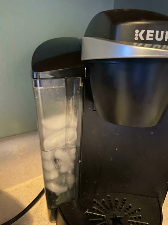 A Keurig coffee maker filled with ice cubes instead of water, a dumb way to try and make coffee.