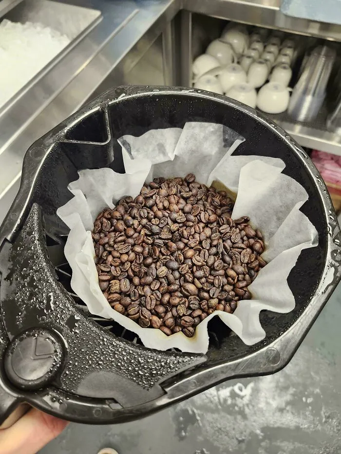 A coffee filter overflowing with dry coffee beans, a dumb way to prepare coffee.