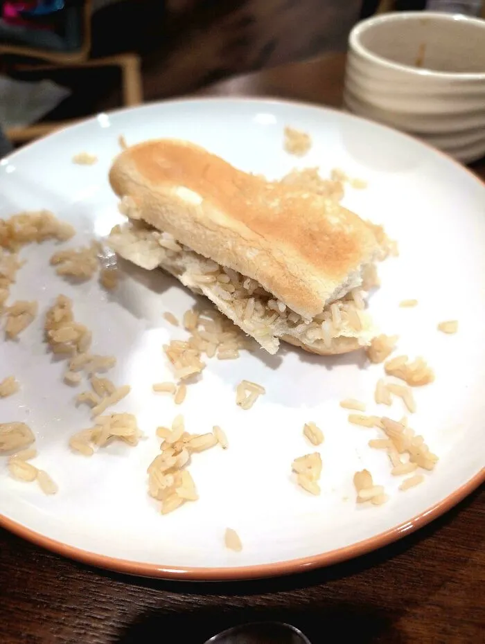 A plain bread roll stuffed only with white rice, illustrating questionable food combos.