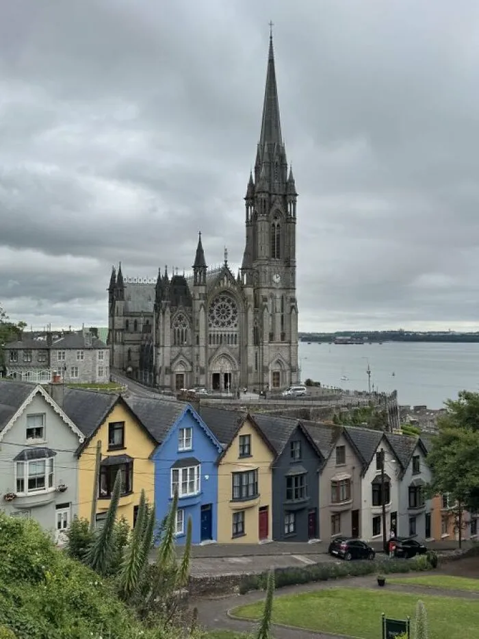 Picturesque town with a grand cathedral towering over colorful houses, epitomizing unique building character.