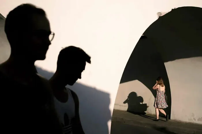 Best street photos from the Macadam Awards capture silhouettes of people and shadows on a white wall.