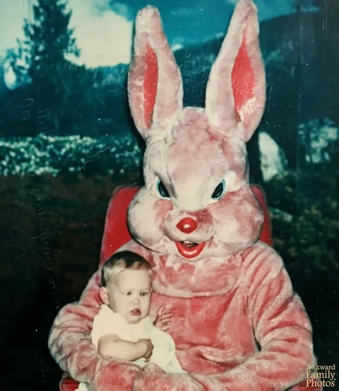 Awkward family photos: A terrified baby sits on a truly terrifying pink character mascot of an Easter bunny.