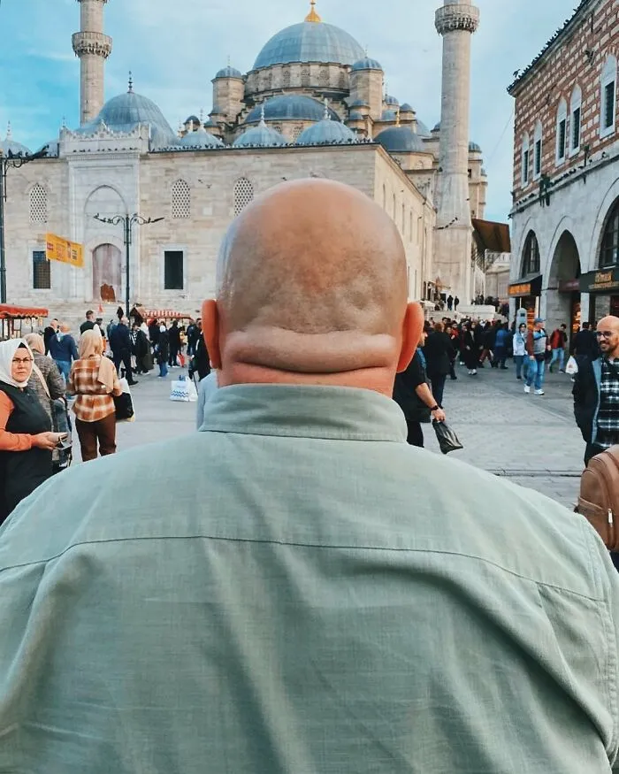 A photographer captured a well-timed street shot from behind a man, with a mosque in the background.