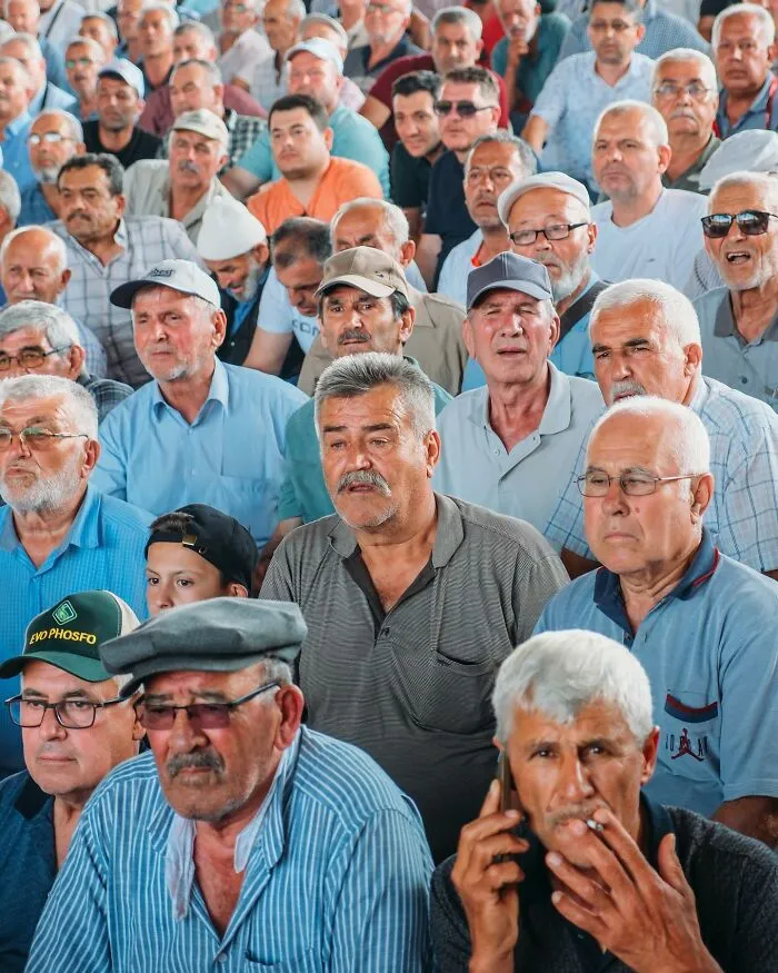 A crowd of men with diverse expressions, a well-timed street shot.