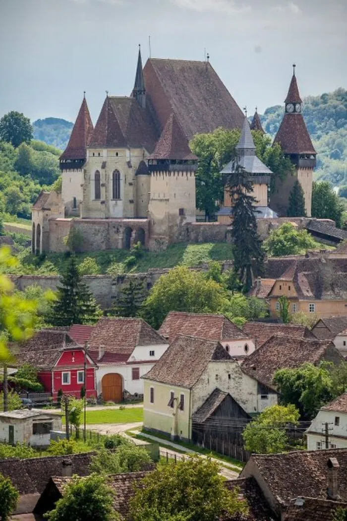 Medieval fortified church surrounded by a village, exemplifying buildings with character that challenge modern designs.