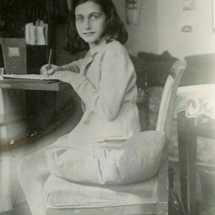 Anne Frank Writing At Her Desk In Her Room In The Merwedeplein Apartment, Amsterdam, 1941