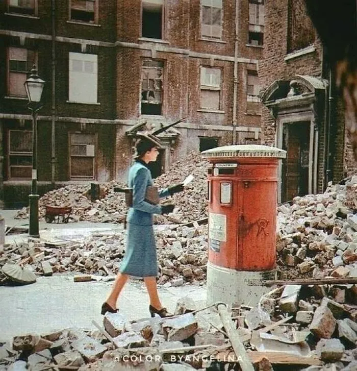 A Woman Posts A Letter In A Postbox Amongst Destroyed Buildings And Rubble Caused By German Air Raids During World War II. Photograph Taken In London, United Kingdom In 1940 By Cecil Beaton