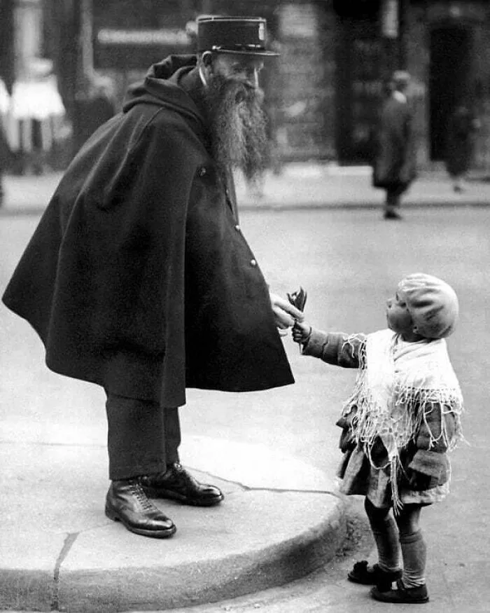 A Little Girl Hands A Posy Of Lilies To A Police Officer On Duty At The Porte Saint-Denis In Paris, Circa 1920