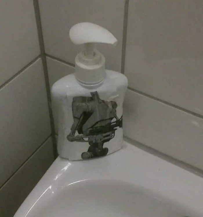 A soap dispenser with a bizarre, unhinged image of a robot on it, a truly random object.