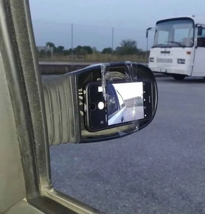 A phone taped to a car mirror, an unhinged image that is truly cursed.