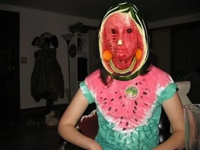 A person with a watermelon carved to fit their head as a mask, an unhinged and cursed image.
