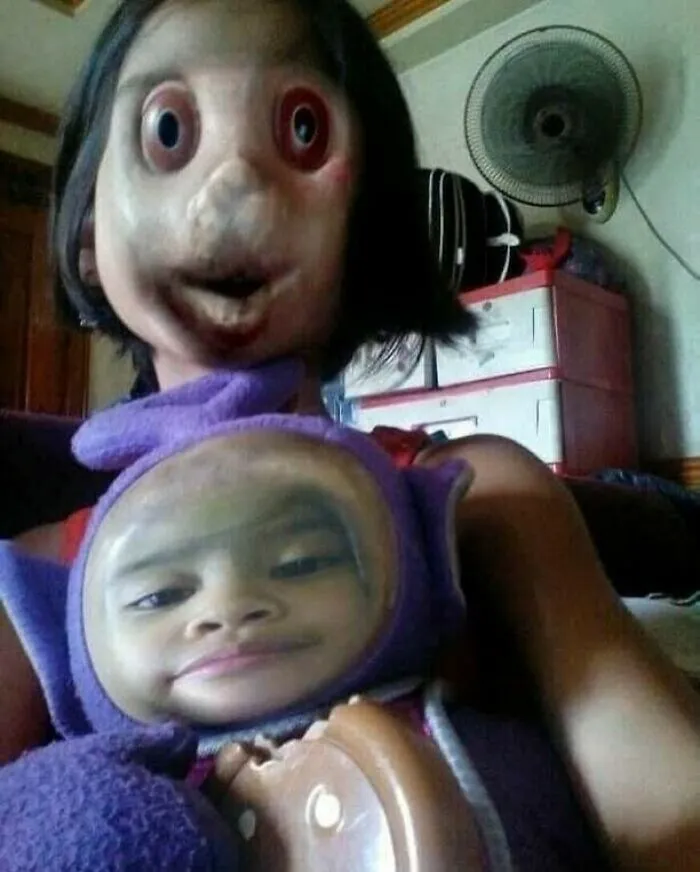 A distorted face in a mirror image with a baby on the lap, an unhinged and cursed image.