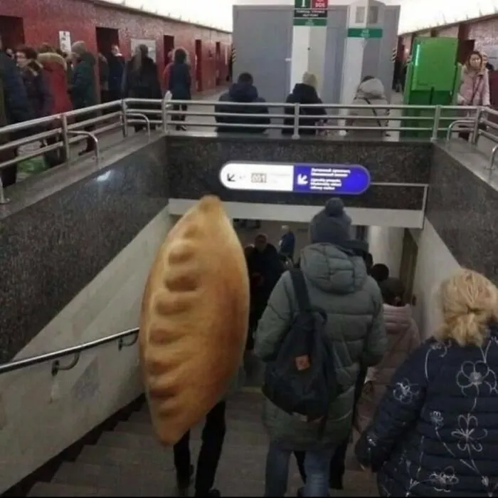 A cursed image of a person in a giant pierogi costume descending stairs in a busy public transit station.